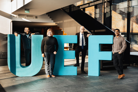 Group of staff standing with large UEF letters.