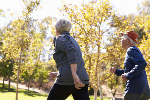 Couple power walking through park