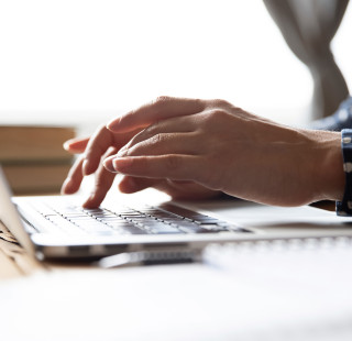 Student is writing at laptop